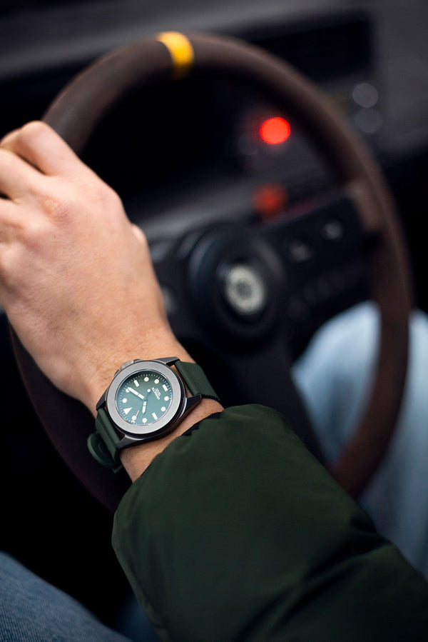 A wrist shot of the Unimatic x Automobili Amos in the drivers seat of a Lancia Delta Integrale